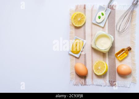 ingredienti per preparare la salsa maionese fatta in casa. senape, gas, limone, olio vegetale. su sfondo bianco, spazio per il testo copyspace Foto Stock