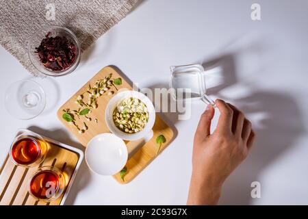 Festa del tè cinese. Granuli secchi di diversi tipi di tè. Flatlay, vista dall'alto. Tè alle erbe, su sfondo bianco Foto Stock