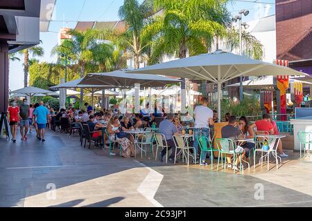 Punta Umbria, Huelva, Spagna - 3 giugno 2020: Huelva, Spagna - 27 luglio 2020: Persone che siedono nella terrazza di un bar e bar nel centro commerciale Holea. Alcuni Foto Stock