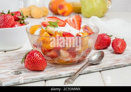 Macedonia di frutta fresca con yogurt in una ciotola - fitness colazione Foto Stock