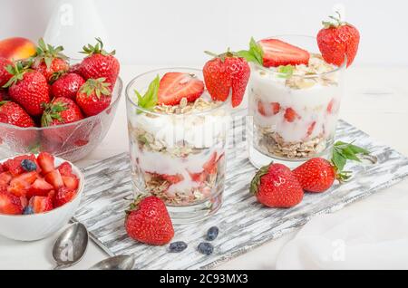 Muesli con yogurt e fragole fresche su fondo bianco. Foto Stock