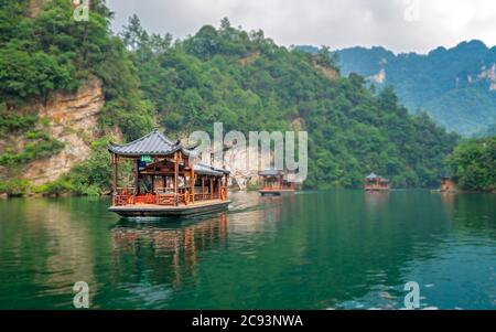 Zhangjiajie, Cina - Agosto 2019 : Barche turistiche che navigano tra paesaggi carsici incredibilmente belli che circondano il lago Baofeng, Wulingyuan, Zhangji Foto Stock