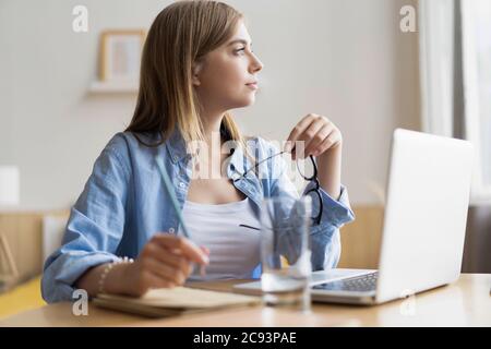 Lavorare a casa mi consente di lavorare in modo flessibile. Piacevole felice giovane donna freelance che lavora sul computer a casa. Foto Stock