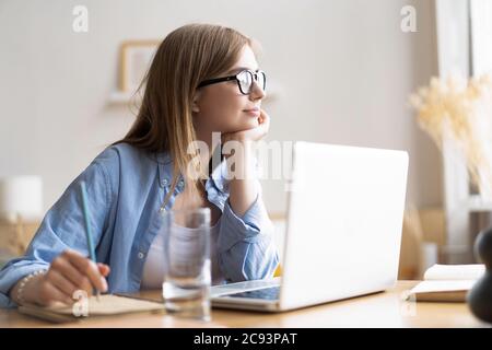 Lavorare a casa mi consente di lavorare in modo flessibile. Piacevole felice giovane donna freelance che lavora sul computer a casa. Foto Stock