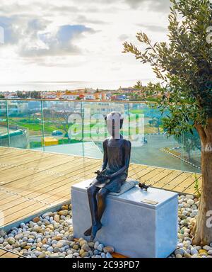 Paphos, CIPRO - 15 FEBBRAIO 2019: La scultura della ragazza e della Sparrow al punto di vista turistico, skyline aereo con paesaggio urbano e cielo nuvoloso Foto Stock