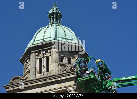 Victoria, British Columbia, Canada, 28, luglio 2020 - i lavoratori cambiano le lampadine e le corde di luce su una delle cupole dello storico edificio del Parlamento nel centro di Victoria. L'edificio ospita l'Assemblea legislativa della British Columbia che governa la provincia. Don Denton/Alamy Live News Foto Stock