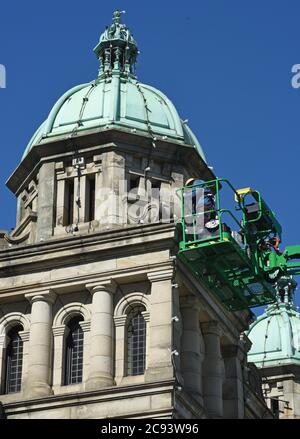 Victoria, British Columbia, Canada, 28, luglio 2020 - i lavoratori cambiano le lampadine e le corde di luce su una delle cupole dello storico edificio del Parlamento nel centro di Victoria. L'edificio ospita l'Assemblea legislativa della British Columbia che governa la provincia. Don Denton/Alamy Live News Foto Stock