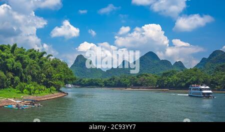 Yangshuo, Cina - Agosto 2019 : Barca turistica che trasporta i turisti che navigano tra gli splendidi paesaggi di montagna carsica sul magnifico fiume li tra il G Foto Stock