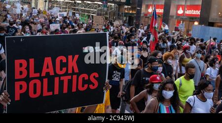 Black Womens/Womxn March Black Lives Matter protesta - Black Politics firma con una folla enorme dietro di esso Foto Stock