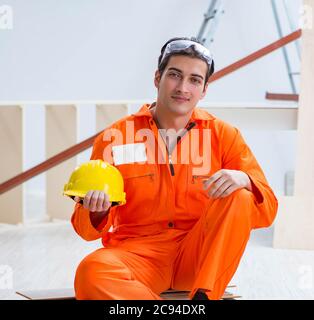 Il falegname che indossa il giallo hardhat contraente in officina Foto Stock