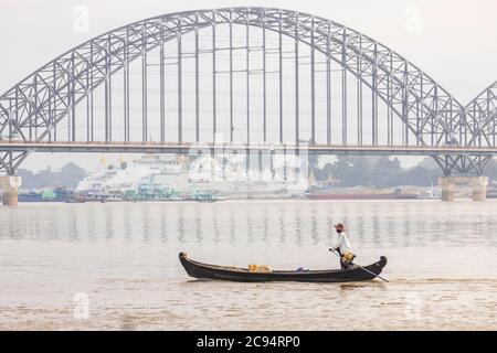 Sagaing/Myanmar-3 ottobre 2019: Un pescatore birmano sta guidando una piccola barca da pesca sul fiume Ayeyarwady vicino al ponte di Ayeyarwady. Foto Stock