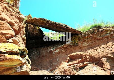 Una lastra di pietra naturale si trova sulla cima di una collina formando un arco. Catena montuosa Chests, Khakassia, Sud Siberia, Russia. Foto Stock