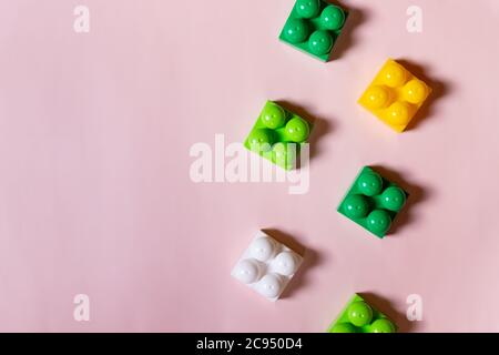 Giocattoli blocchi cornice, mattoni vividi costruzione plastica, gruppo di colorful giochi pieces.colorful giocattoli bambino su sfondo rosa. Blocchi di sviluppo. Creativo Foto Stock
