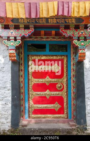 Porta al Monastero di Tsodzong, una cappella di Nyingmapa sull'isolotto al largo della riva di Draksum Tso (o Basom Tso), un lago sacro a Kham, Tibet orientale, Cina Foto Stock