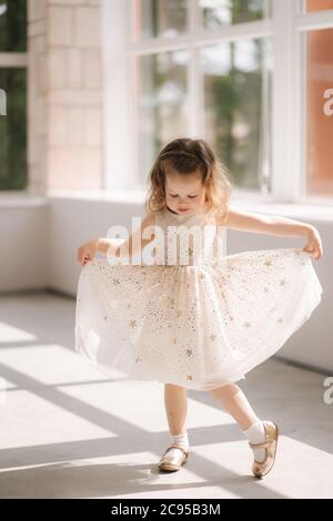 Carino bambina di tre anni in posa vestito per photograper in studio. Beutiful bambina danza Foto Stock