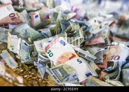 Composizione di banconote e monete in euro in un secchio gigante. Concetto aziendale Foto Stock
