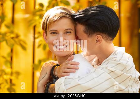 Ritratto di giovane donna felice sorridente alla macchina fotografica mentre la sua ragazza abbracciando la sua all'aperto Foto Stock