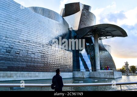 Un viaggiatore che guarda al Museo Guggenheim di Bilbao Foto Stock