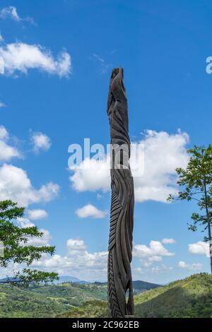 Enorme totem in legno tipico caledoniano nuovo. Parc des Grandes Fougères, Nuova Caledonia. Il cielo è blu Foto Stock