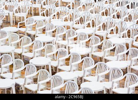 Tavoli e sedie bianche in fila per un evento. Foto Stock