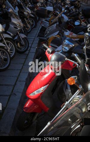 File di scooter a motore parcheggiati sulla strada della città. Foto Stock