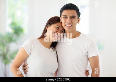 Giovane coppia asiatica felice nell'amore. Uomo e donna abbracciano e ridono a casa. Datazione e relazione. Fidanzata e fidanzata in vacanza. San Valentino Foto Stock