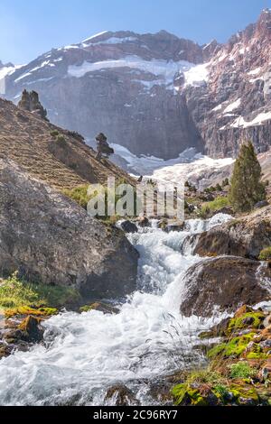 La bellissima strada per il trekking in montagna con cielo azzurro e colline rocciose e il fresco ruscello di montagna nelle montagne di Fann in Tagikistan Foto Stock