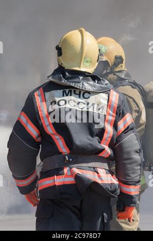 Vista posteriore con emblema EMRCOM della Russia su vigili del fuoco uniformi del Ministero della Difesa civile, emergenze, soccorso in caso di disastri della Federazione russa MCH Foto Stock