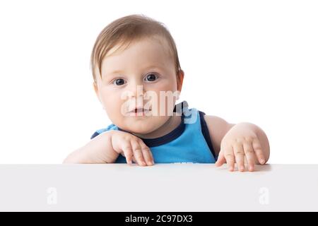 Cute bambino ragazzo che guarda sorpreso. 5 mesi bambino pronto a giocare con i giocattoli. Foto Stock