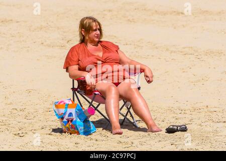 Weymouth, Dorset, Regno Unito. 29 luglio 2020. Regno Unito Meteo. Una donna seduta sulla spiaggia nella località balneare di Weymouth in Dorset in una calda giornata di sole. Picture Credit: Graham Hunt/Alamy Live News Foto Stock