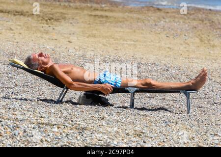 Weymouth, Dorset, Regno Unito. 29 luglio 2020. Regno Unito Meteo. Un uomo che prende il sole sulla spiaggia nella località balneare di Weymouth in Dorset in una calda giornata di sole. Picture Credit: Graham Hunt/Alamy Live News Foto Stock