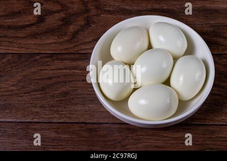 Uova sbucciate bollite senza guscio su uno sfondo. Ingredienti per cucinare. Foto Stock