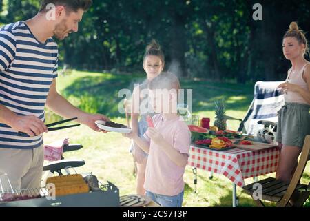 Famiglia pronto a mangiare un barbecue Foto Stock