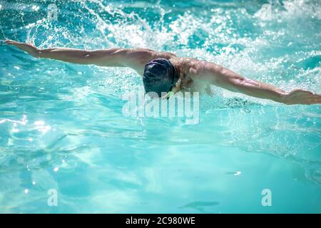 Nuotatore maschile professionista che ha un allenamento in piscina Foto Stock