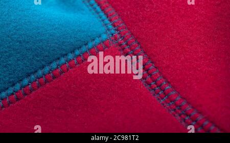 Cuciture della giacca in pile blu rosso, primo piano foto Foto Stock