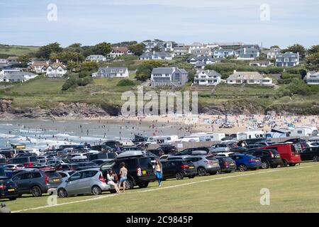 Polzeath, Cornovaglia, Regno Unito. 29 luglio 2020. Regno Unito Meteo. Surfers e vacanzieri hanno imballato nelle acque una spiaggia a Polzeath mentre le temperature cominciano ad aumentare, davanti all'onda di calore prevista alla fine della settimana. Credit Simon Maycock / Alamy Live News. Foto Stock