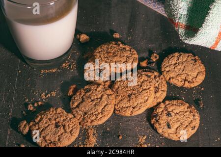 Cippi di cioccolato fatti in casa biscotti e un bicchiere di latte su un tavolo di legno Foto Stock