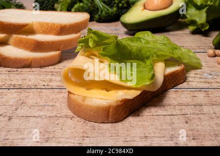 Sandwich semplice e appetitoso con pane, formaggio e lattuga. Foto Stock