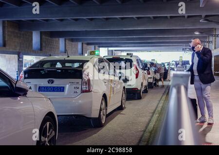 Stazione dei taxi all'aeroporto di Siviglia. Fuoco selettivo su un taxi. Sfondo e primo piano sfocati. Foto Stock