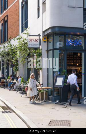 Le persone seduti ai tavoli da pranzo al fresco al 28-50 Wine Workshop e Kitchen Wine bar bistro, Marylebone Lane, Londra, Inghilterra, Regno Unito Foto Stock