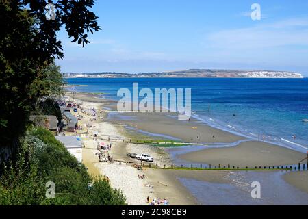 Shanklin, Isola di Wight, Regno Unito. 18 luglio 2020. I turisti sulla spiaggia di Chine a bassa marea con la baia di Sandown presa dai gradini di Appley a Shanklin sulla i Foto Stock