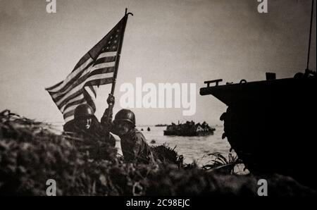 Marines STATUNITENSI battenti le Stelle e le strisce sulla spiaggia di Guam durante la seconda battaglia di Guam (21 luglio – 10 agosto 1944), la ricattura americana dell'isola di Guam, tenuta in Giappone, Un territorio degli Stati Uniti nelle Isole Marianne catturato dai giapponesi dagli Stati Uniti nella prima battaglia di Guam del 1941 durante la campagna del Pacifico della seconda guerra mondiale Foto Stock