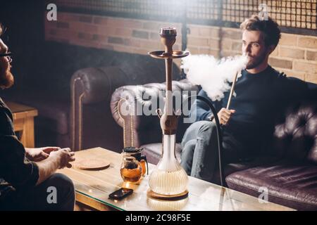 i colleghi discutono dei problemi al lavoro al bar. Nargile turco per i visitatori. Primo piano Foto Stock