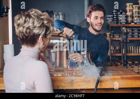 tradizioni e costumi. Drink turco. Bardak. Cameriere giovane e piacevole che versa il tè nel bicchiere. Primo piano. Foto Stock