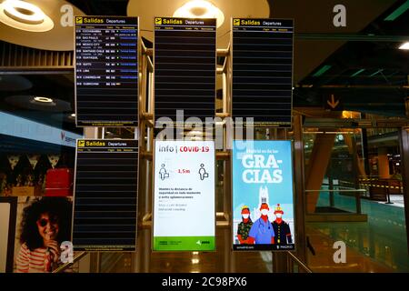 28 luglio 2020, Aeroporto Barajas, Madrid, Spagna: Un cartello di informazione Covid-19 e le partenze dei voli quasi vuote si imbarchano nell'area lounge delle partenze dell'edificio del Terminal 4S dell'Aeroporto Barajas. Un numero ridotto di voli è ora operativo tra i paesi europei dopo il blocco per controllare il coronavirus della covid-19, e i governi hanno messo in atto un sistema di ponti aerei per facilitare i viaggi e il turismo. La Spagna ha visto una serie di nuovi focolai negli ultimi giorni, inducendo il governo britannico ad annunciare che le persone che tornano nel Regno Unito dalla Spagna dovrebbero essere in quarantena per 14 giorni all'arrivo. Foto Stock