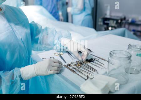 infermiere in guanti sterili strumento di scelta per eseguire la chirurgia. primo piano ritagliato photo.job, professione, occupazione Foto Stock