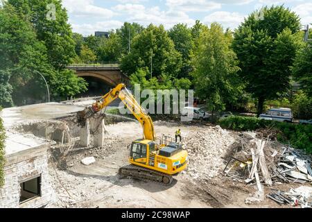 Berlino, Germania - 13 luglio 2020: Un cantiere a Berlino con un escavatore giallo che demolisce una casa Foto Stock