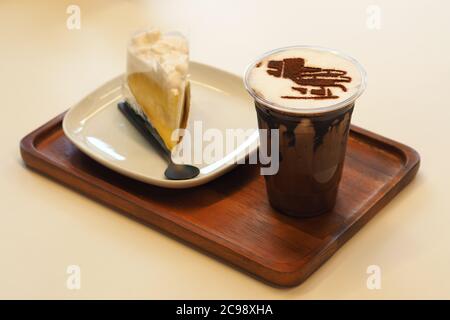 Caffè Iced Mocha al cioccolato con torta alla vaniglia su vassoio di legno Foto Stock