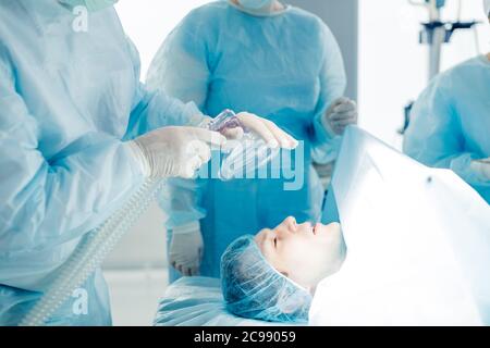 medici che tengono la maschera di ossigeno e la mettono sul paziente in ospedale. primo piano photo.sick uomo pallido ha bisogno di ossigeno Foto Stock