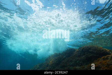 Onda di mare sott'acqua che si infrangono sulla roccia sotto la superficie dell'acqua, Mar Mediterraneo Foto Stock